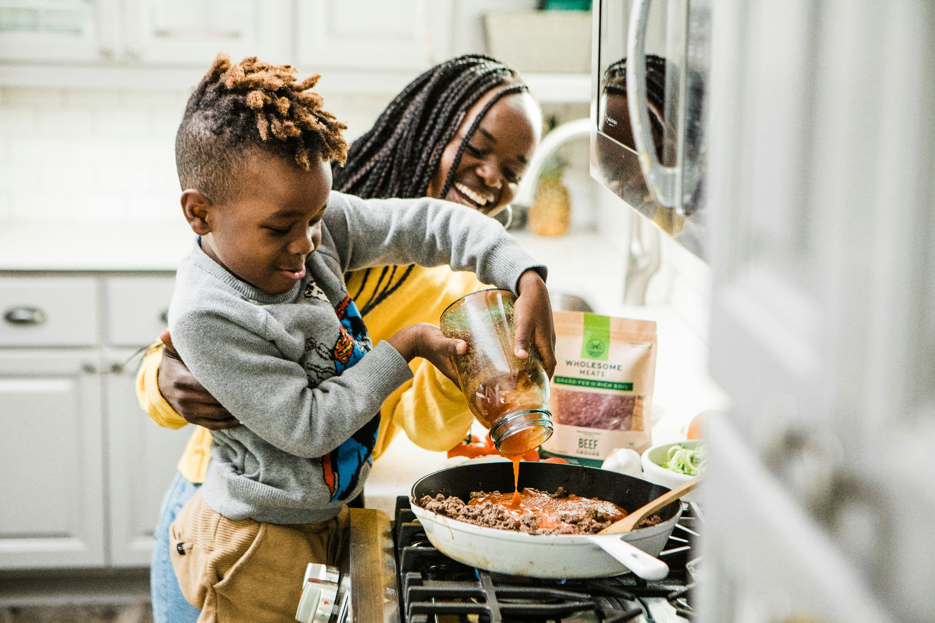 A mother and child cooking together in a bright modern kitchen